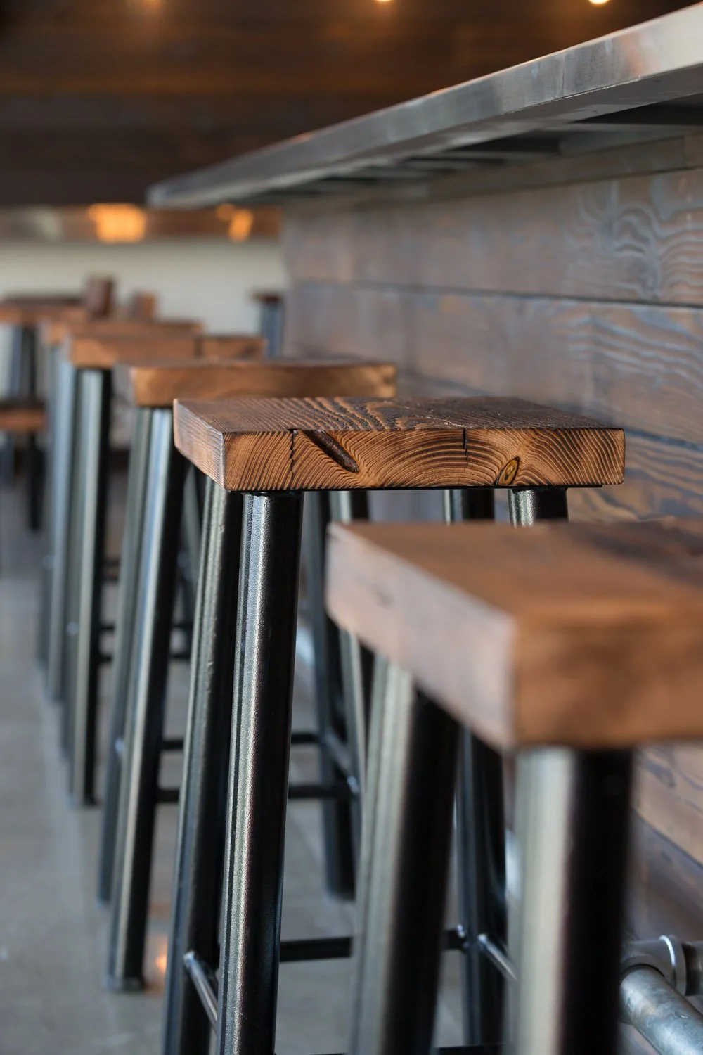 Reclaimed wood bar top with metal bar stools