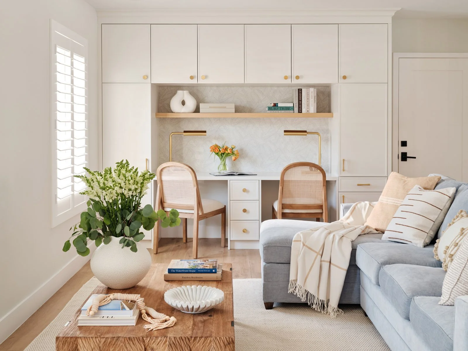 Living room with built-in desk wall and rattan chairs