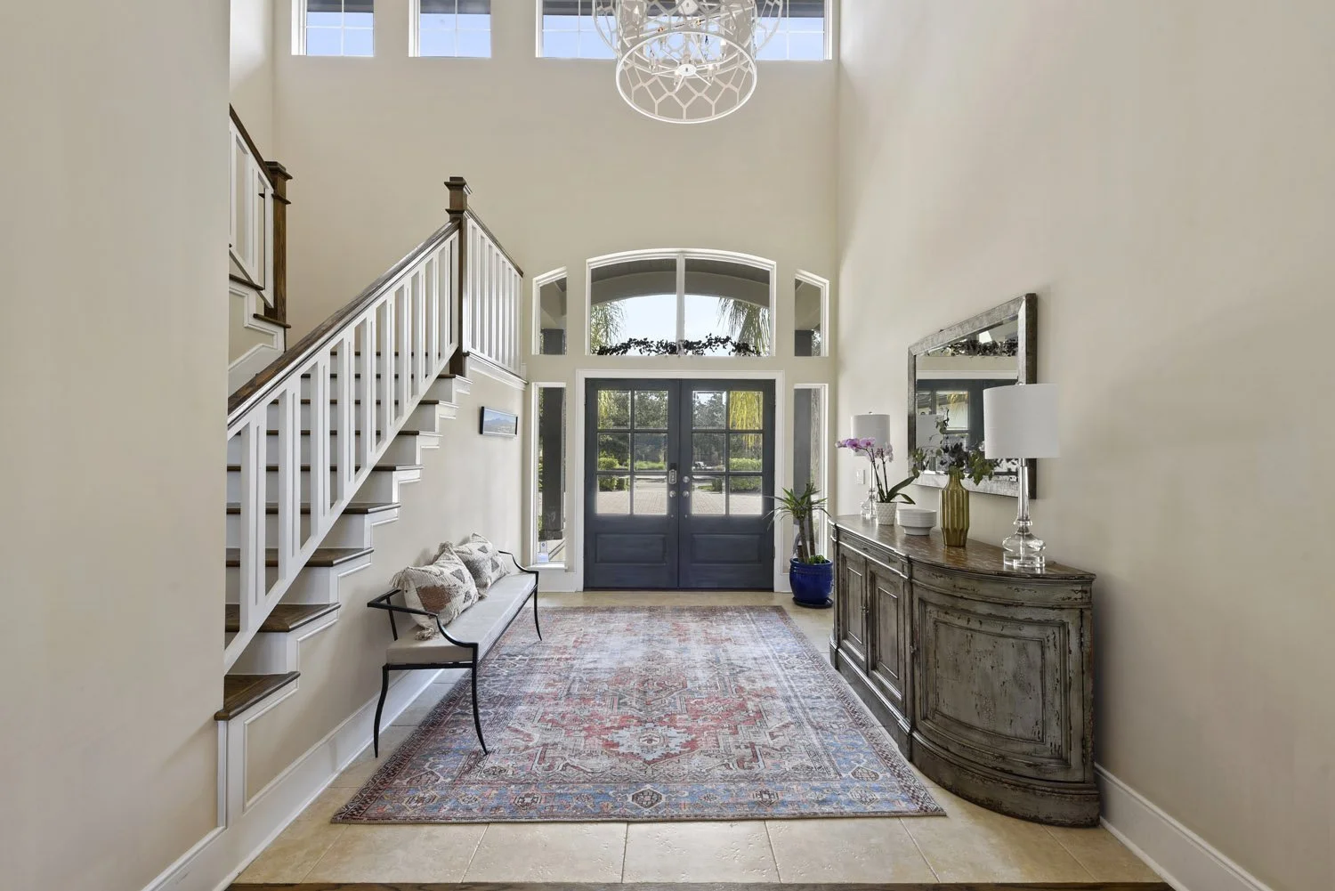 Entry with arched transom windows, chandelier and staircase