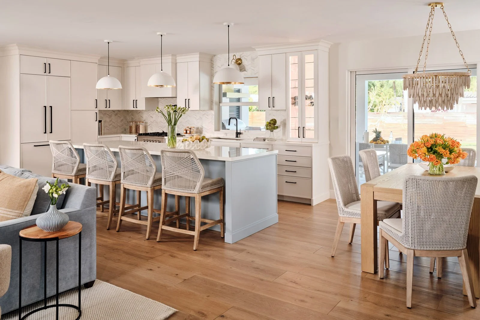 Open kitchen and dining area with white island and bead chandelier