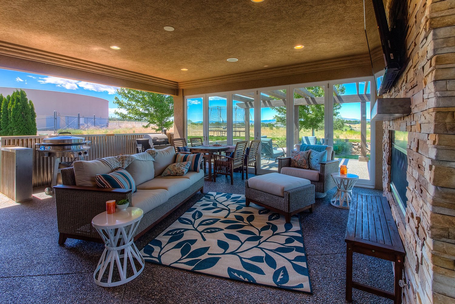 Sunroom with sectional, patterned rug and wood ceiling