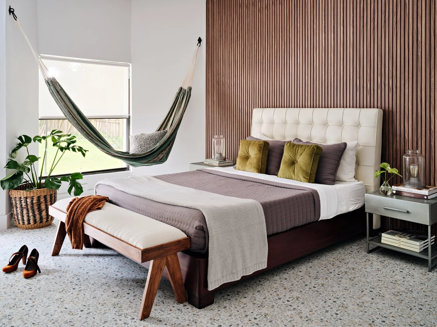 Bedroom with hanging hammock, wood slat accent wall and wood bench
