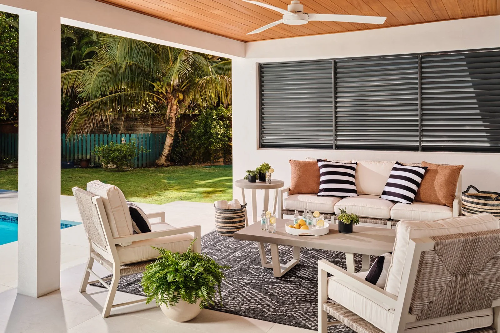 Covered patio lounge with sofa, armchairs and black and white rug