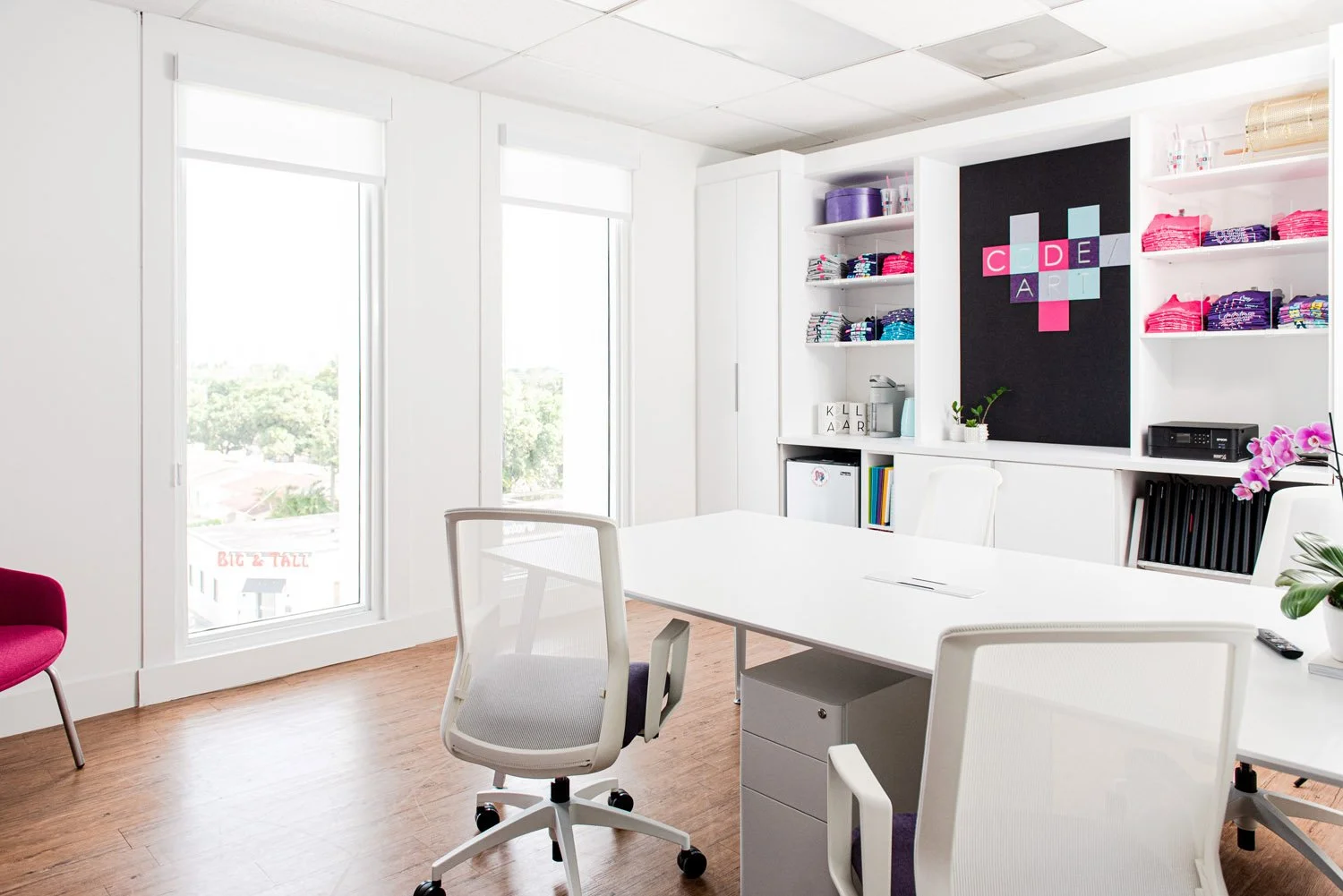 Office with white desks, built-in shelving and pixel heart wall art