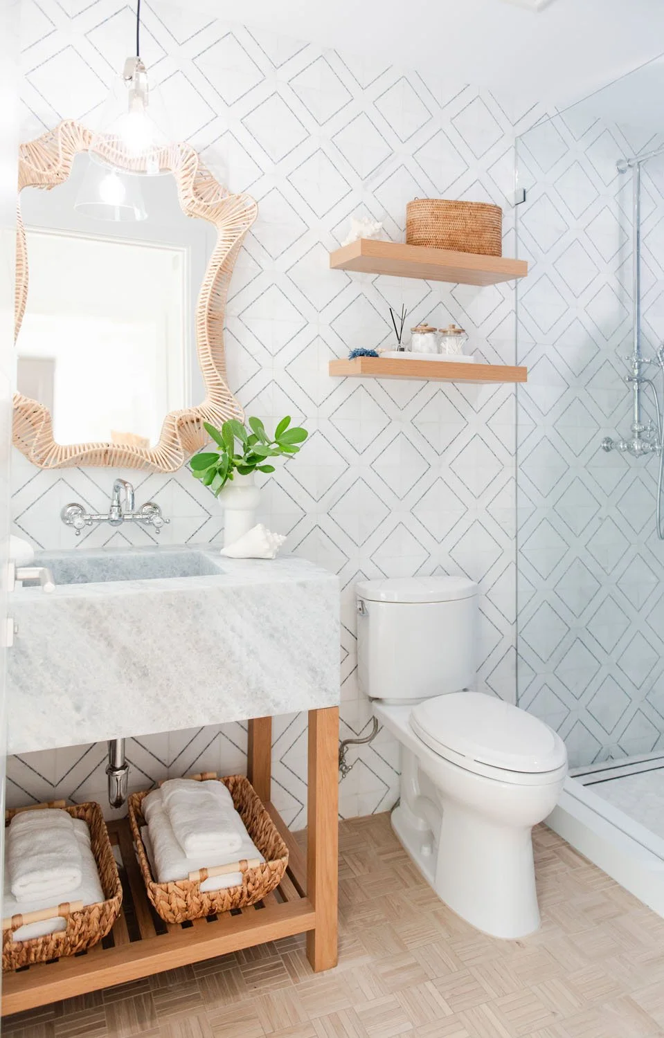 Powder room with rattan wave mirror and wood shelves