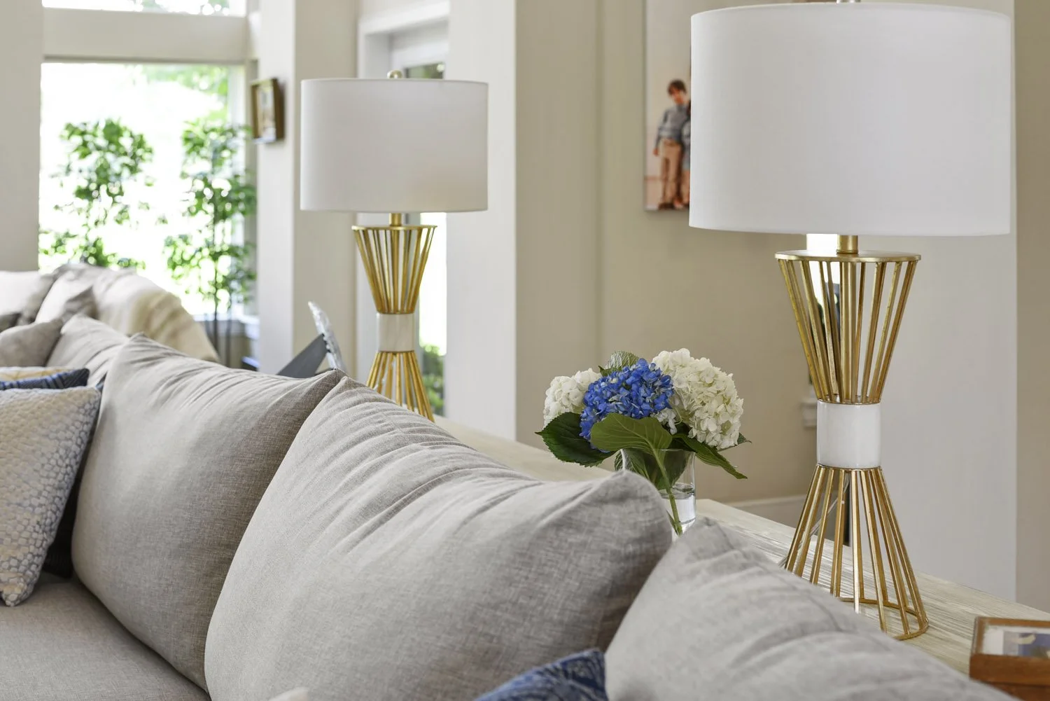 Gold sculptural table lamp beside a gray sofa