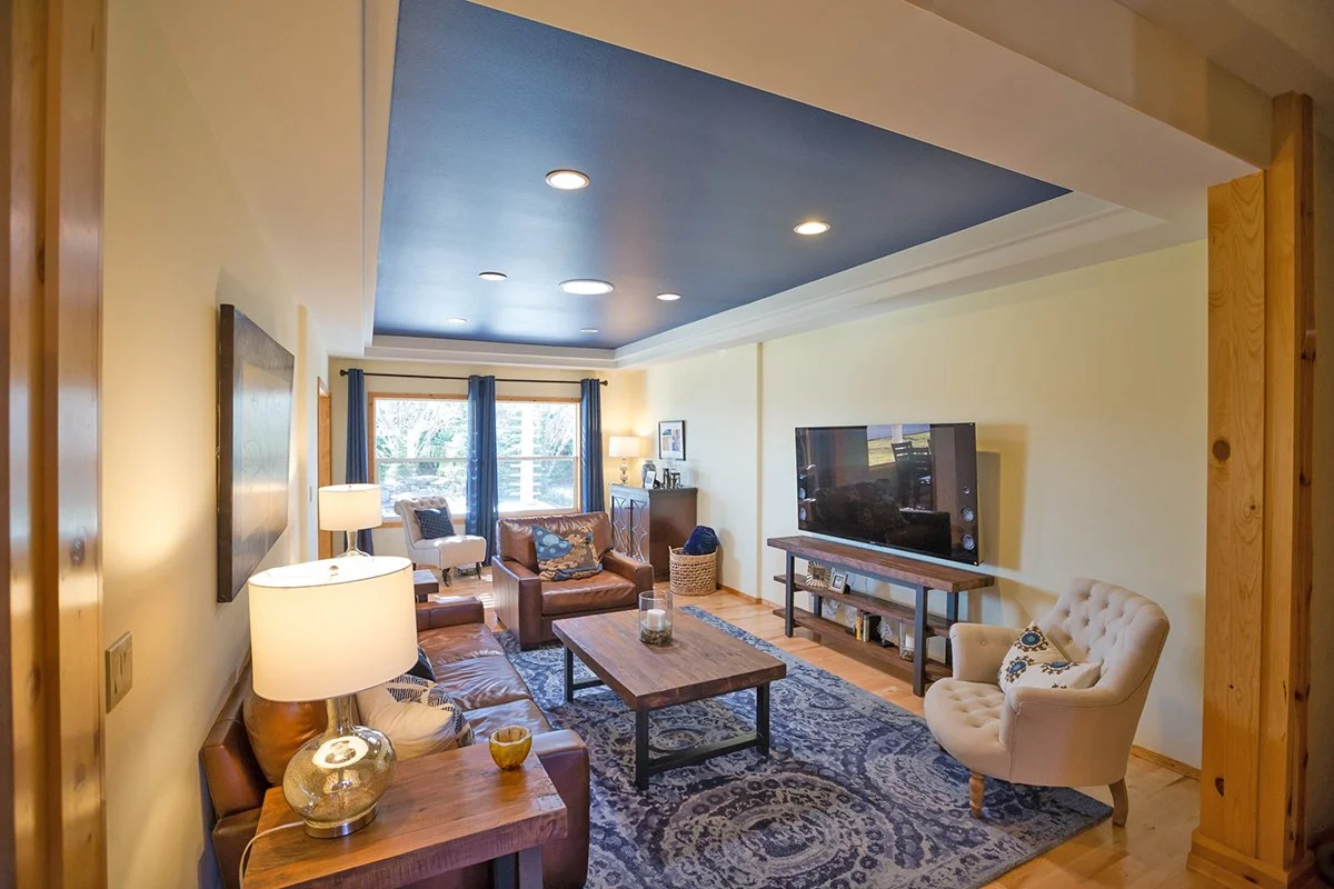 Living room with leather seating, navy ceiling and table lamps