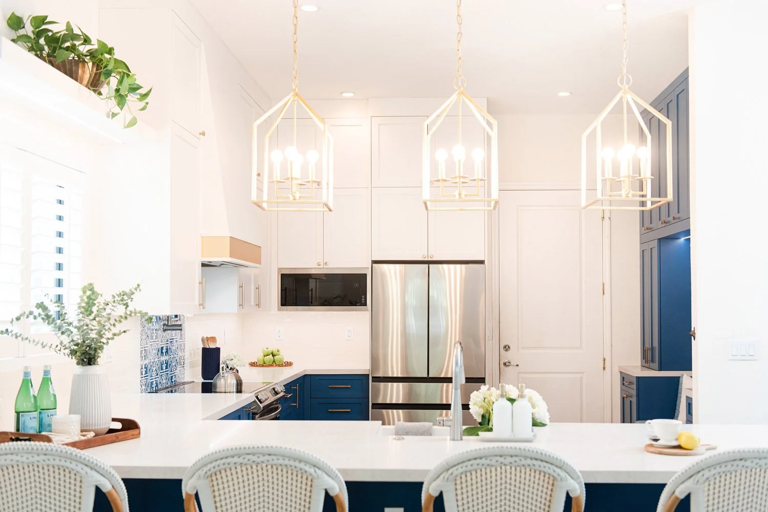Kitchen with brass lantern pendants and white island