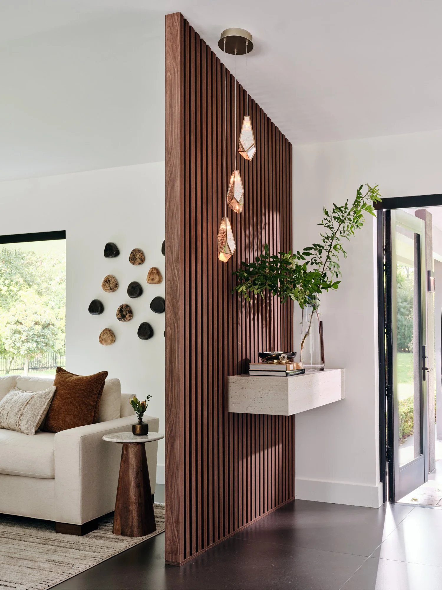 Walnut slat divider with glass pendant lights and floating ledge