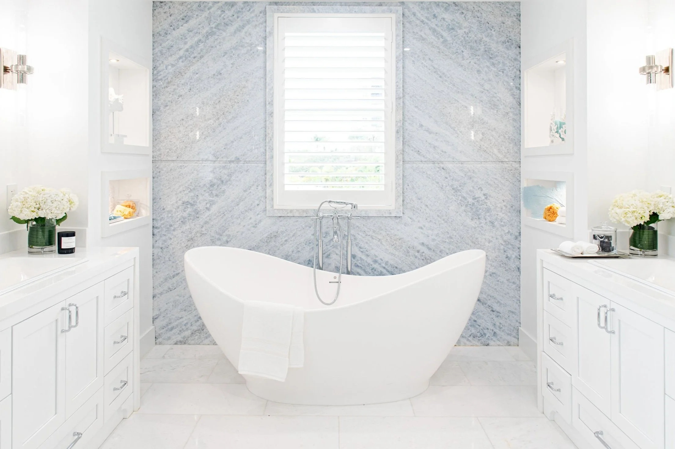 Bathroom with freestanding tub between double vanities