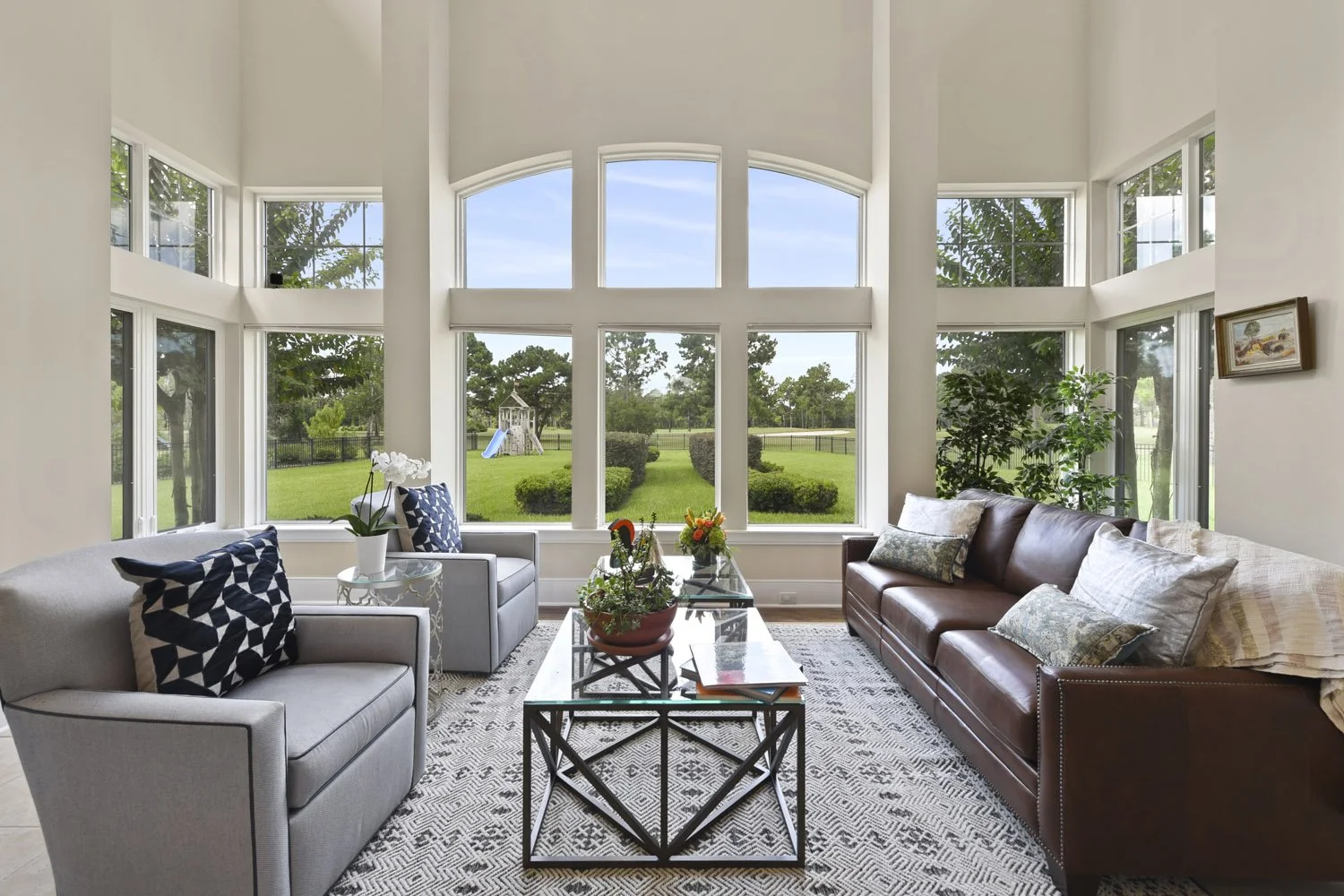 Living area with leather sofa, gray chairs and metal coffee tables