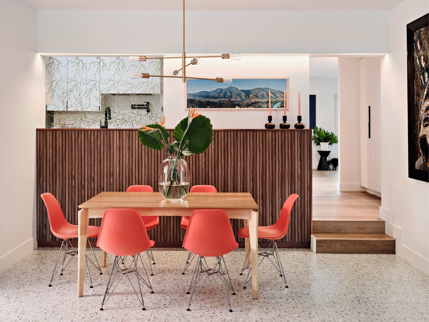 Dining room with coral molded chairs and wood slat wall