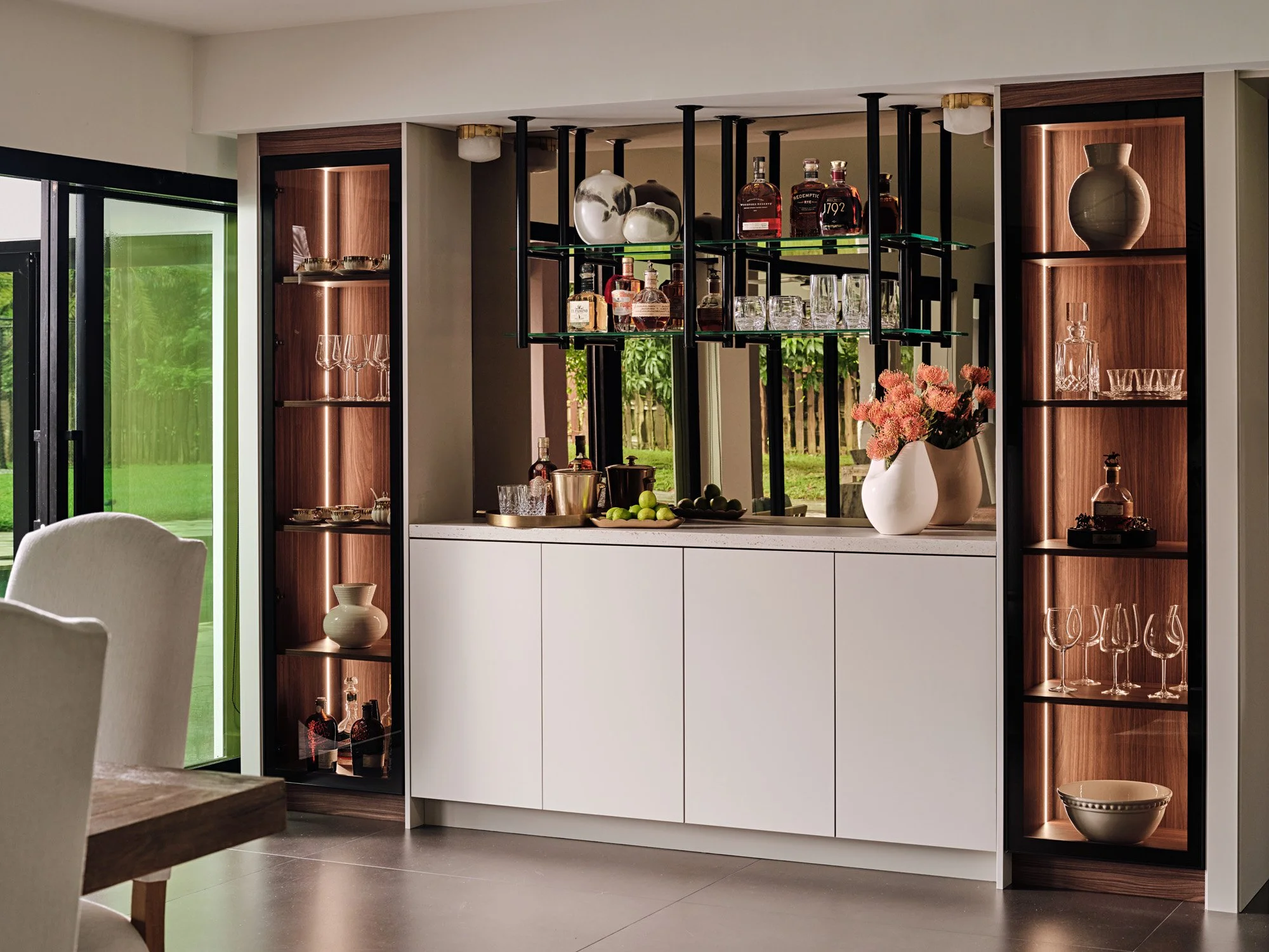 Bar cabinet with lit glass shelving and white lower cabinets