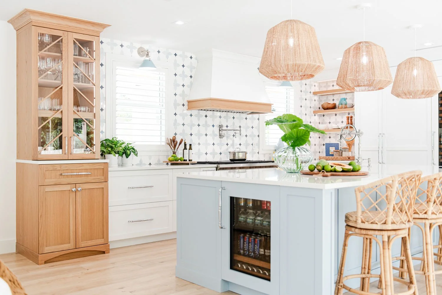 Kitchen with wood hutch, light blue island and rattan stools