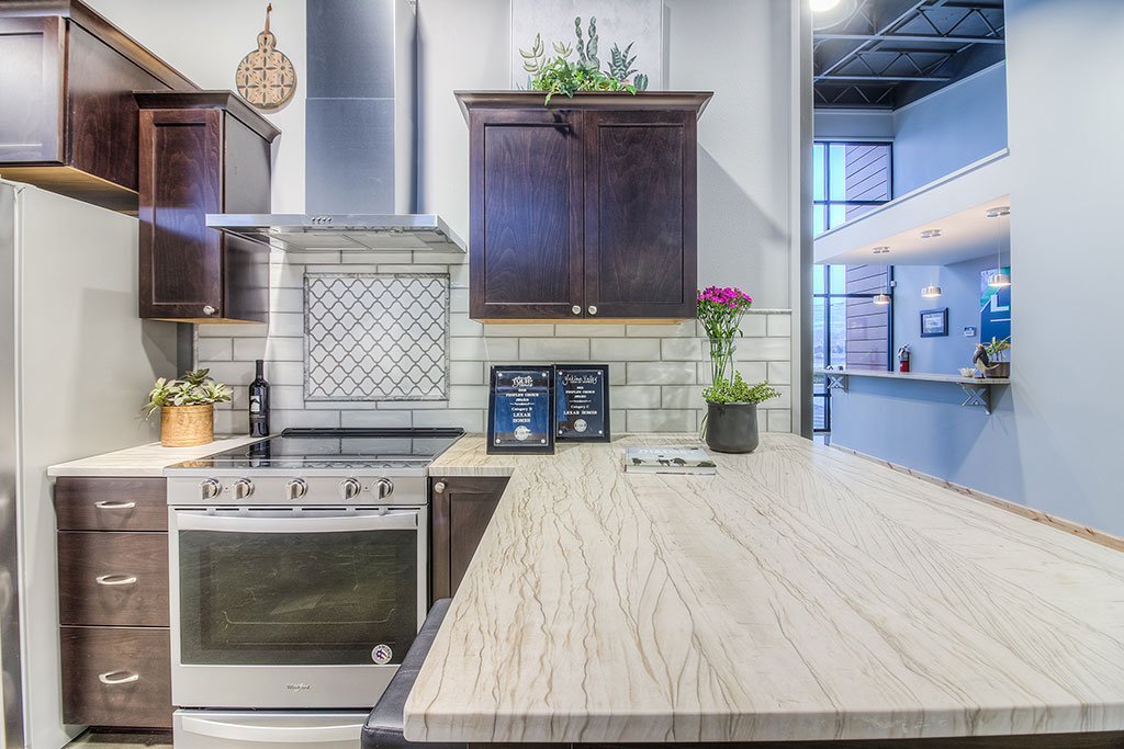 Breakroom kitchen with dark cabinets, stainless range and tile backsplash
