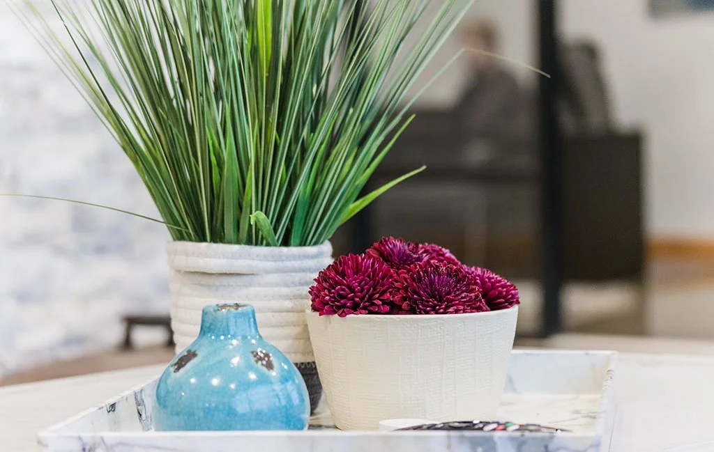 Potted grass and pink flowers on a coffee table tray