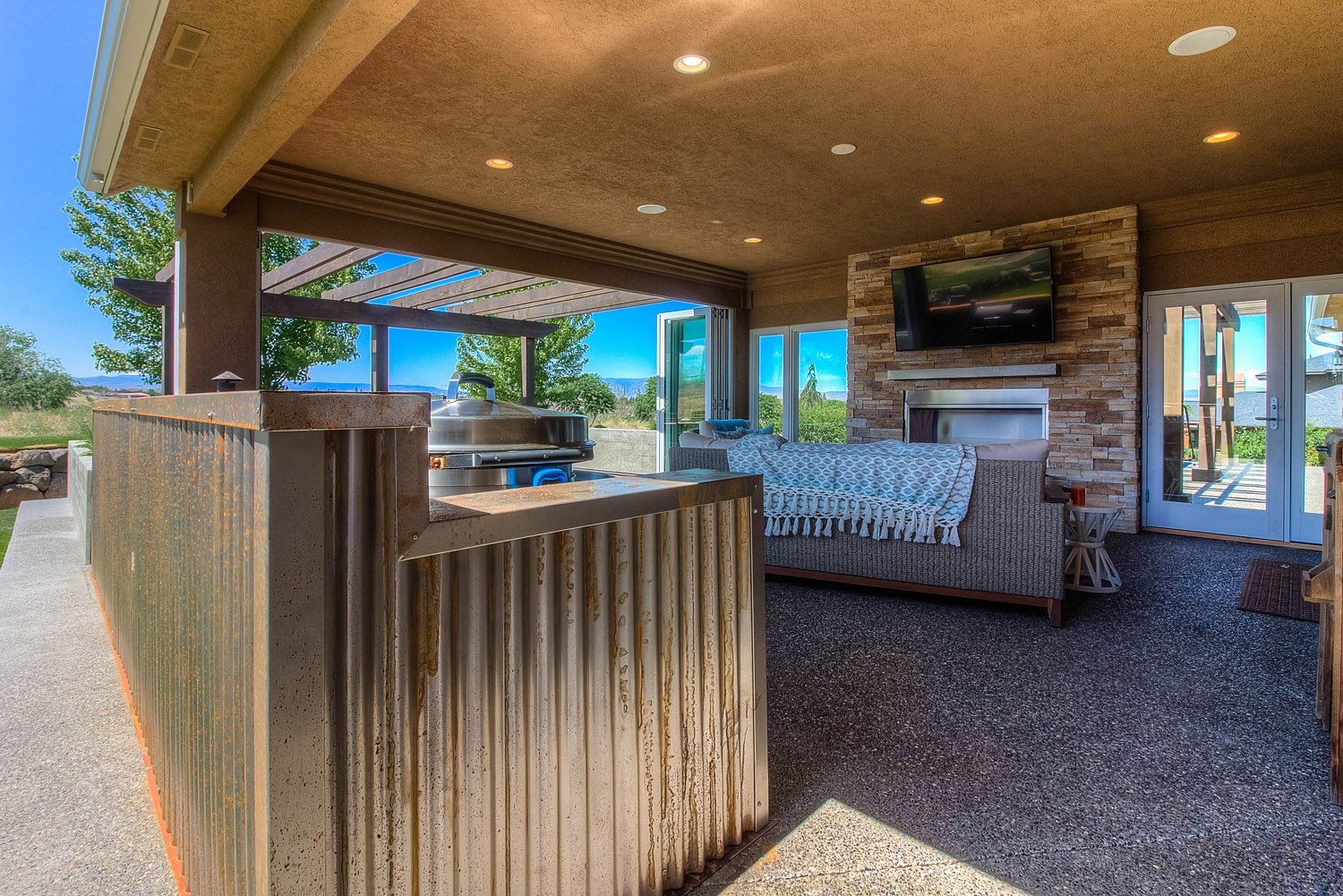 Sunroom with wood railing, sofa and stone fireplace