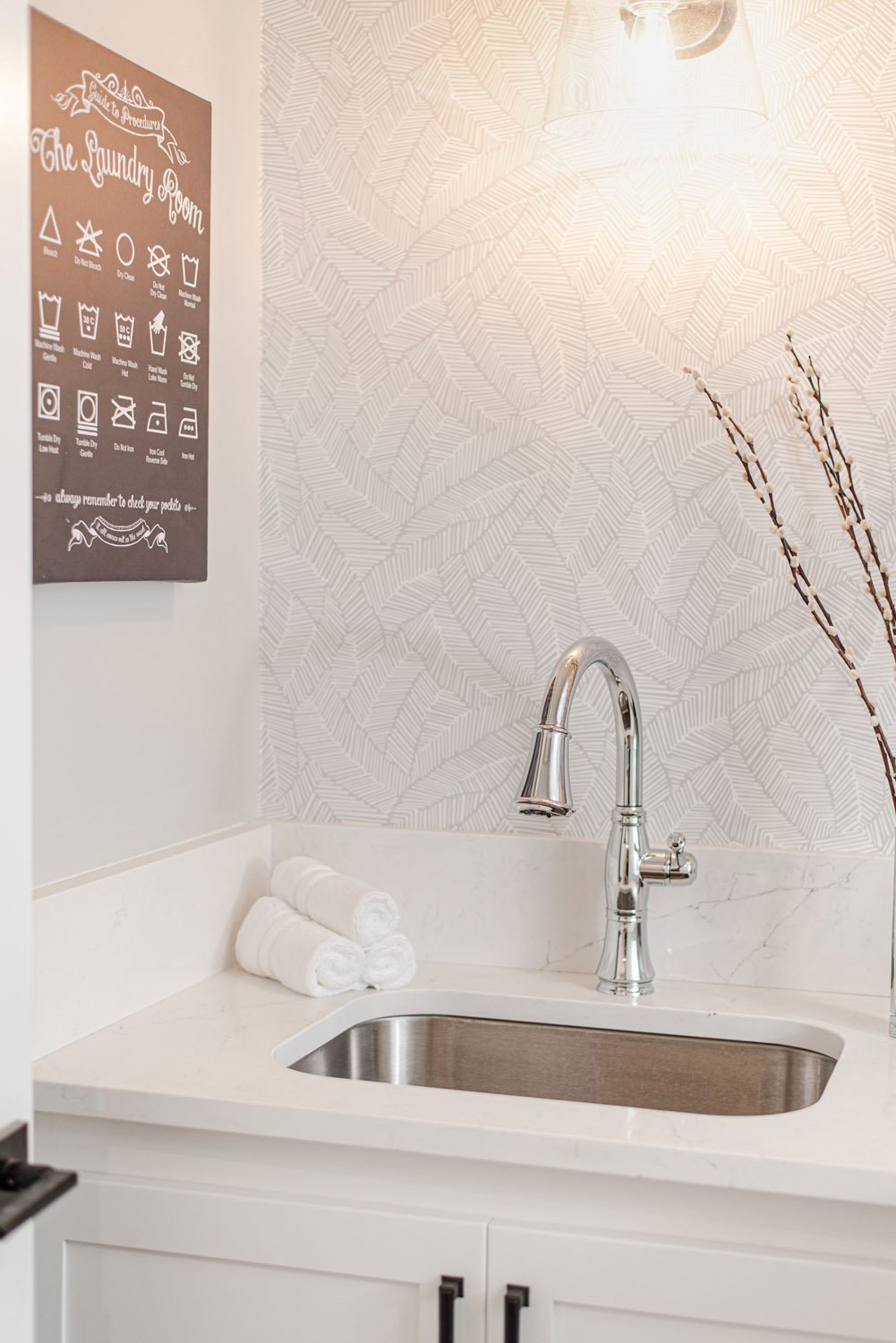 Laundry sink with gooseneck faucet and marble backsplash