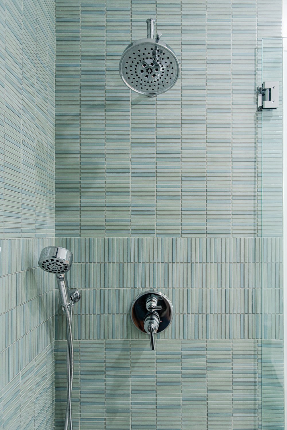 Shower with green vertical tile and rain shower head