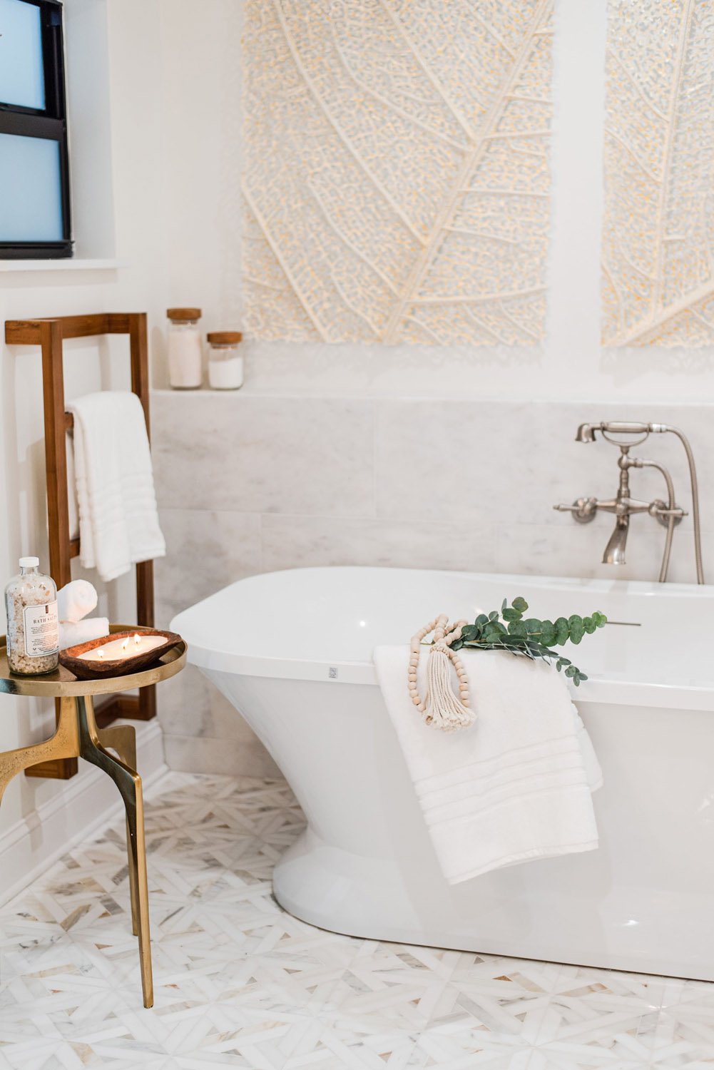Freestanding tub with brass side table and woven wall panels