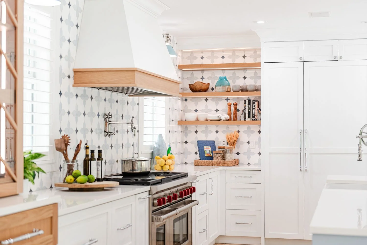 Range wall with wood hood trim, open shelving and patterned tile