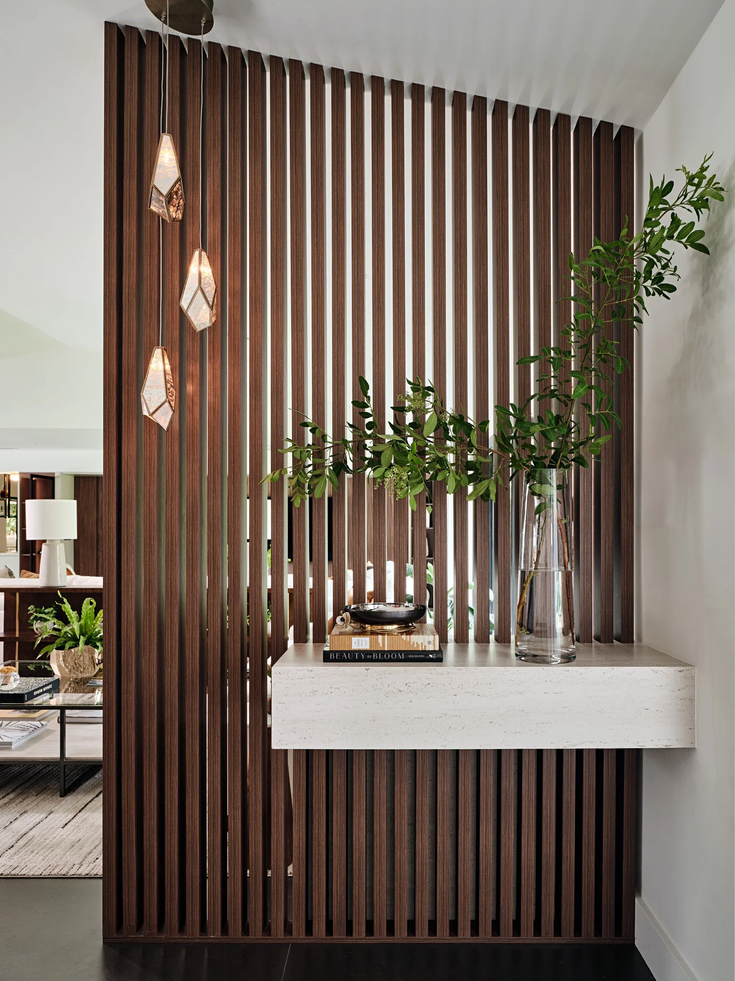 Floating travertine ledge with plants against a walnut slat wall