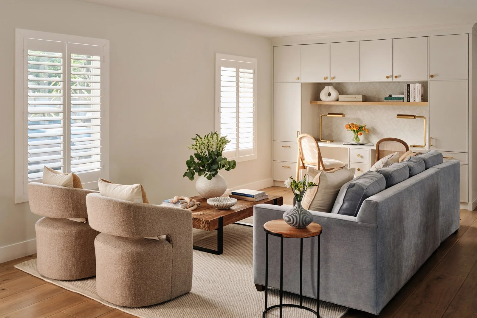 Living room with gray sofa, swivel chairs and open kitchen beyond