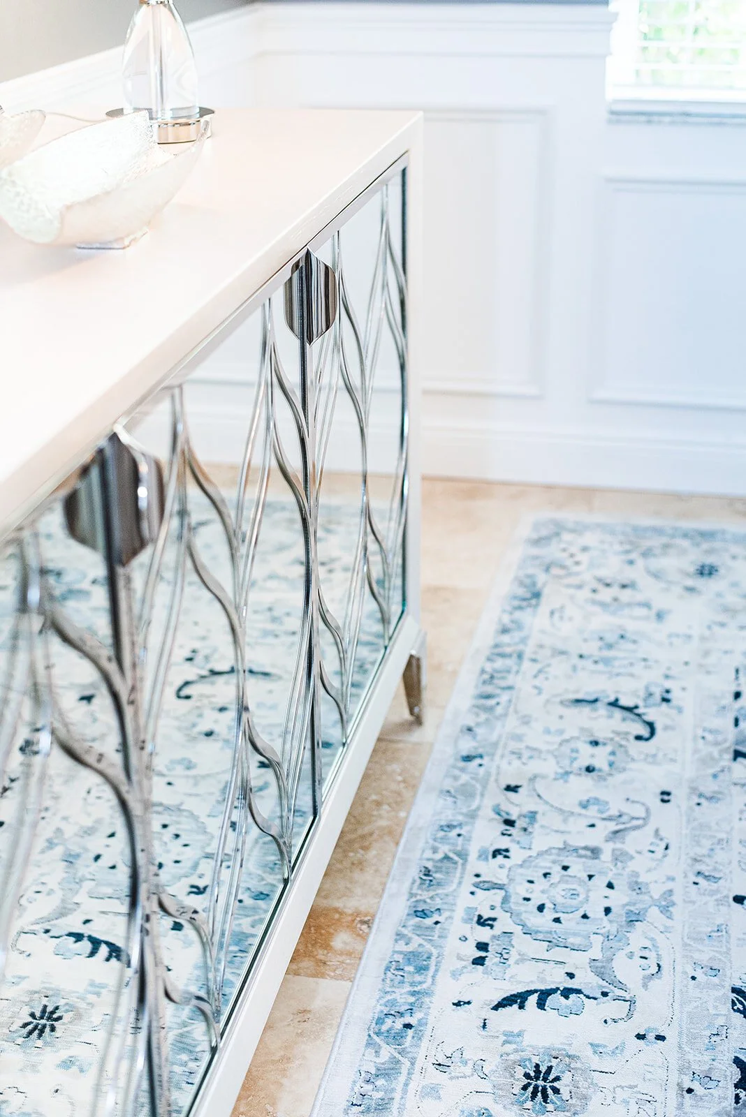 Mirrored sideboard with branch pattern and blue runner rug