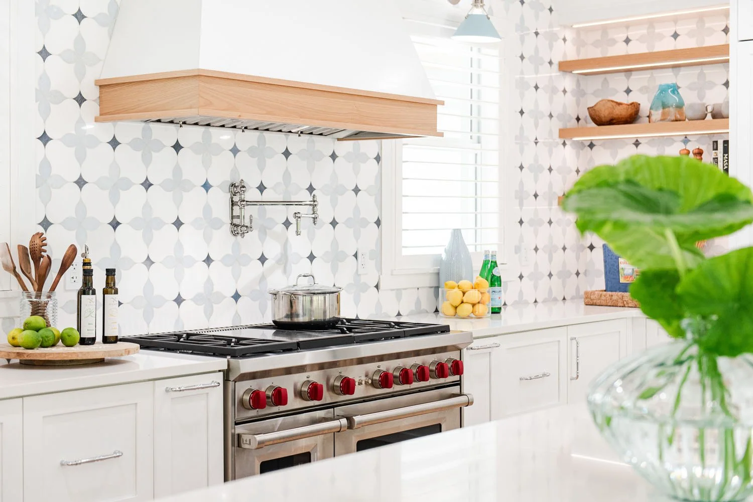 Range wall with wood hood trim, open shelves and patterned tile