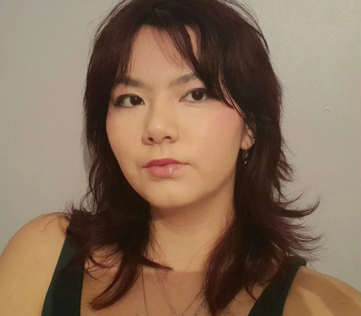 A headshot of a young woman with long dark hair