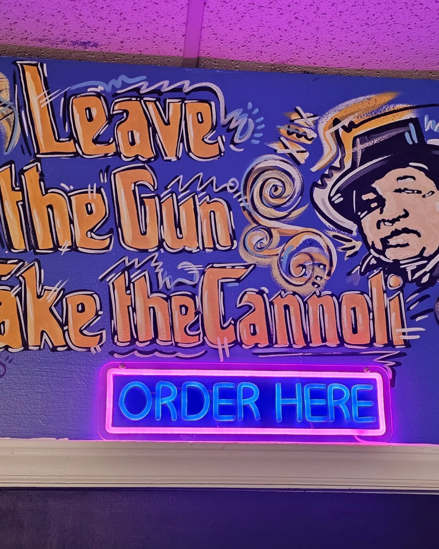 Neon sign with colorful lettering that says "Love up, the human" and a neon box with the words "Order Here".
