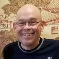 Silhouette of a person's head and shoulders against a light gray background.