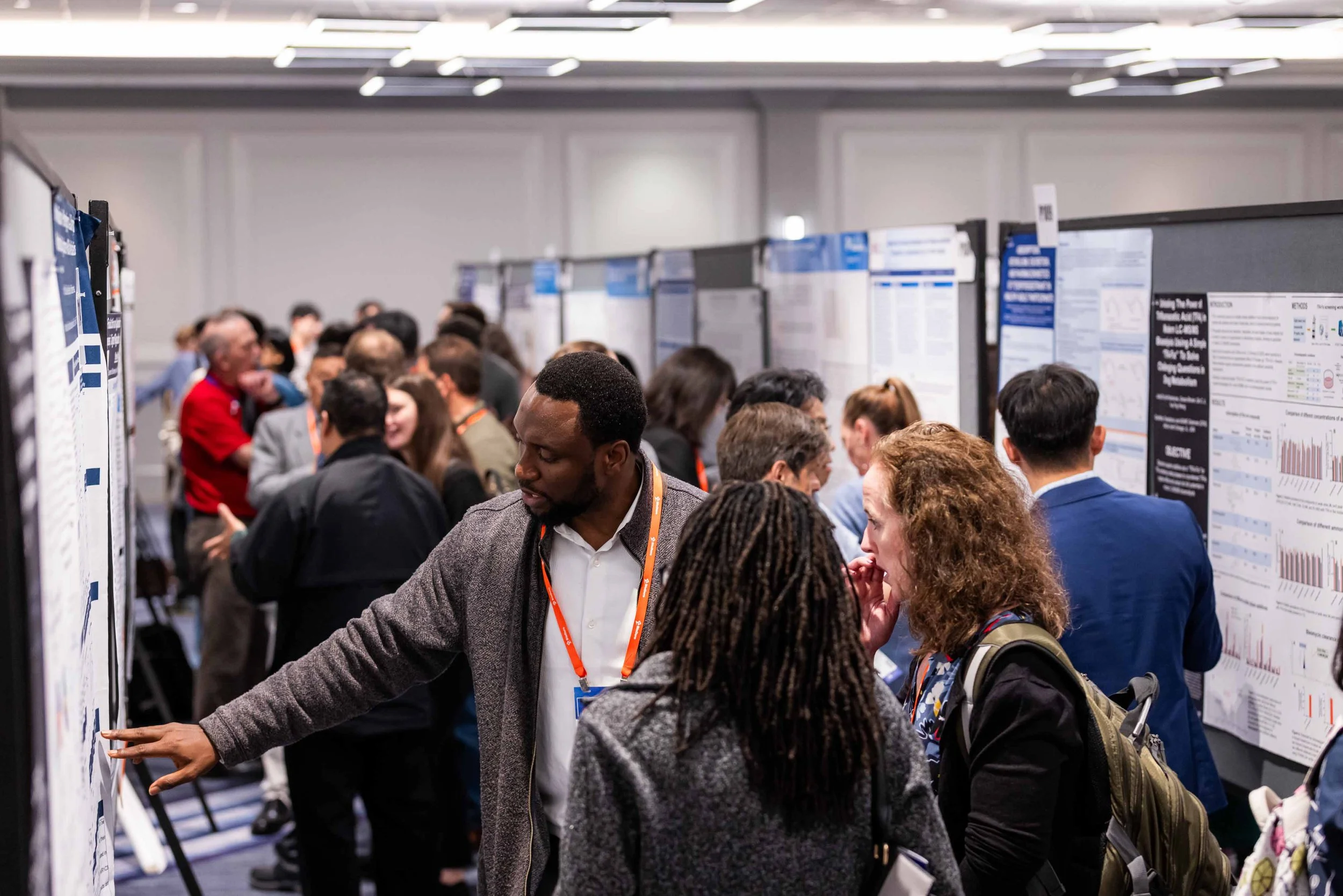 People at a conference viewing research posters on display.