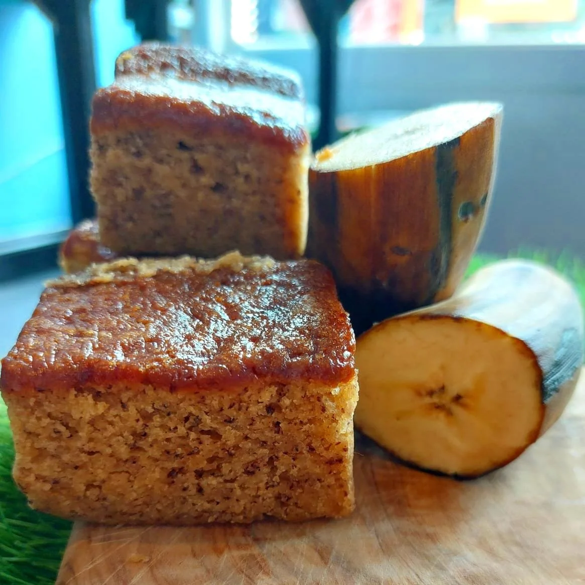 Slices of banana bread and a cut banana on a wooden board.