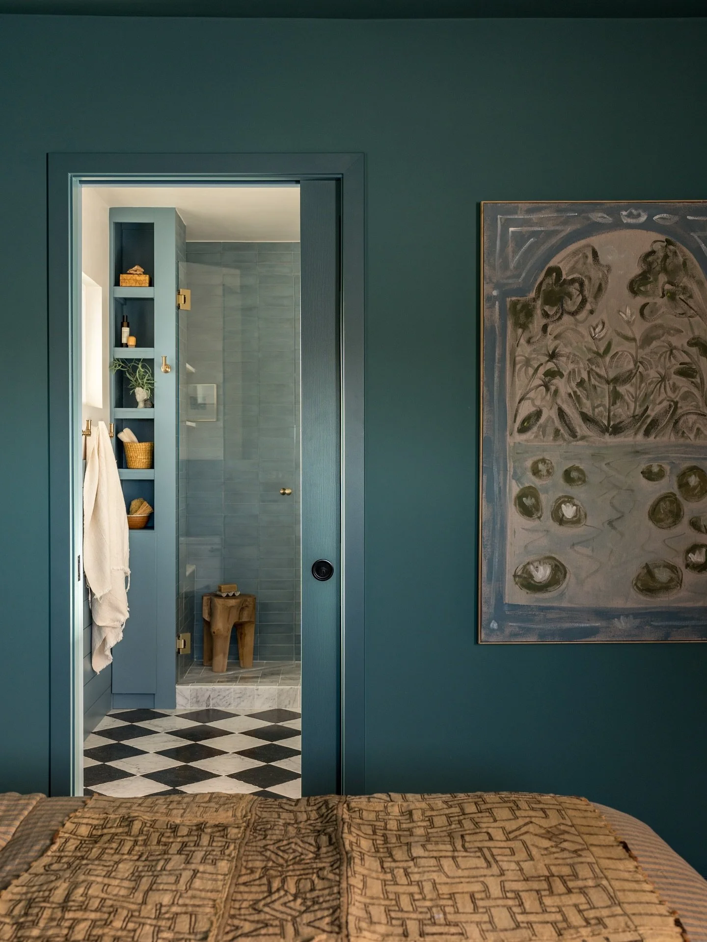 We took color drenching to the next level in this primary suite renovation.  The owners loved this color so we went all in extending it from the moody bedroom into the bathroom.  The shower walls were decked out in beautiful concrete tile while the f