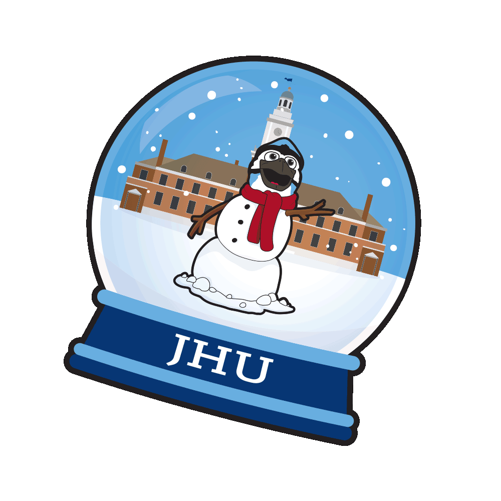 A snow globe featuring a snowman with a red scarf and black goggles, standing in front of a historic building with a clock tower, with snow falling in the background. The base of the globe has the initials "JHU".
