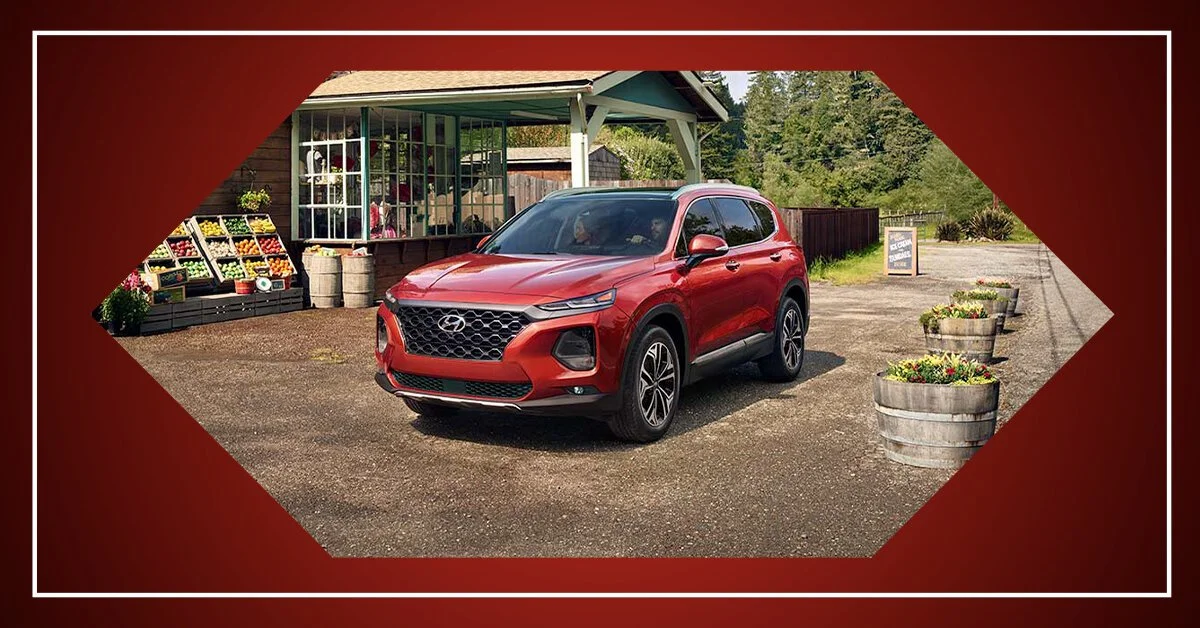 Red SUV parked outside a small farm stand with flowers and produce.