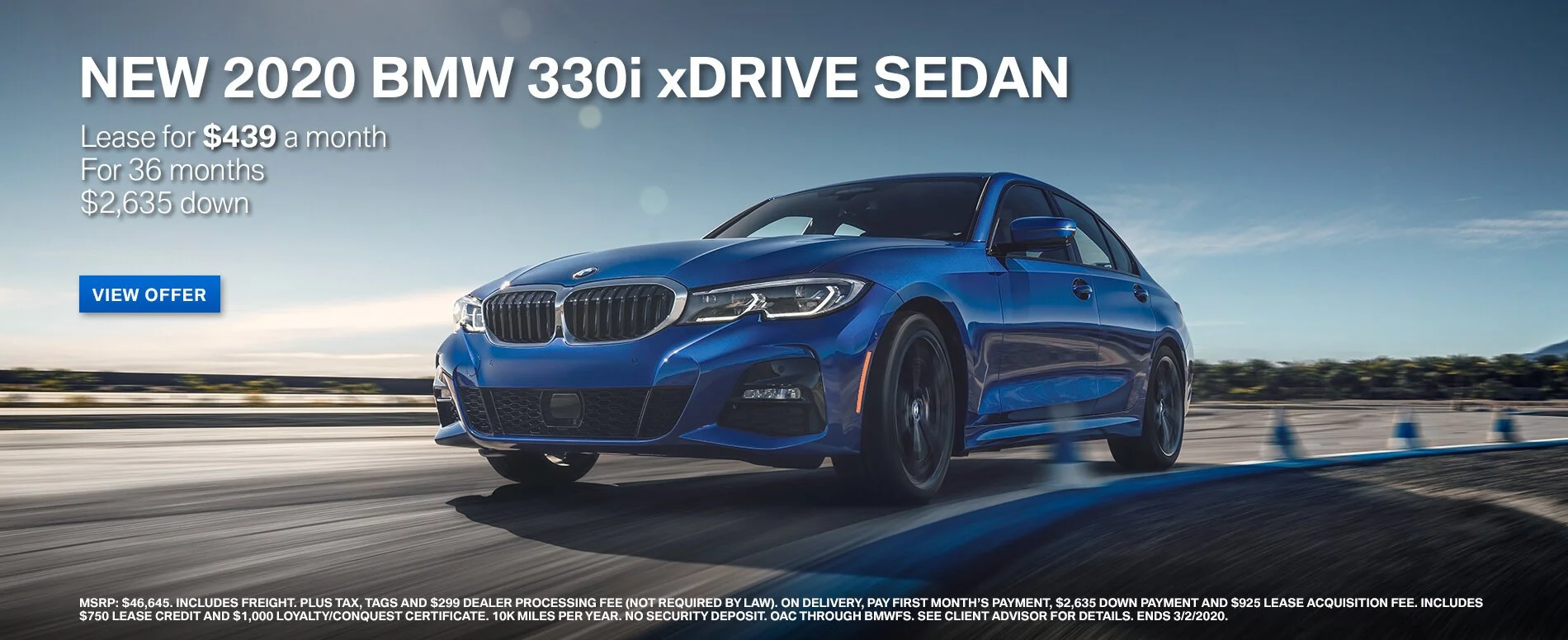 Blue 2020 BMW 330i xDrive sedan driving on a highway with a clear sky in the background and cones along the side.