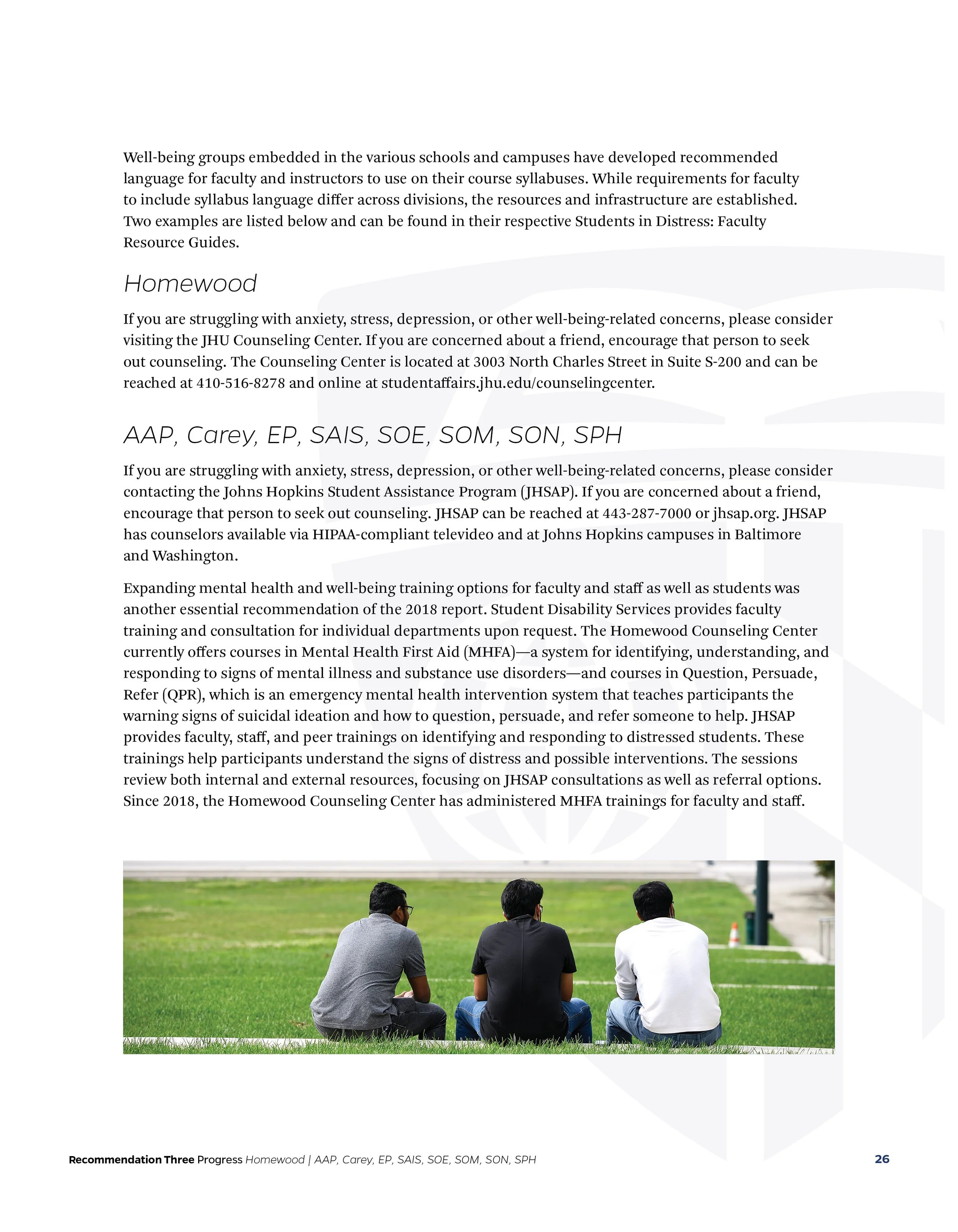 Three individuals sitting on the grass in a park, facing away from the camera, engaging in conversation.