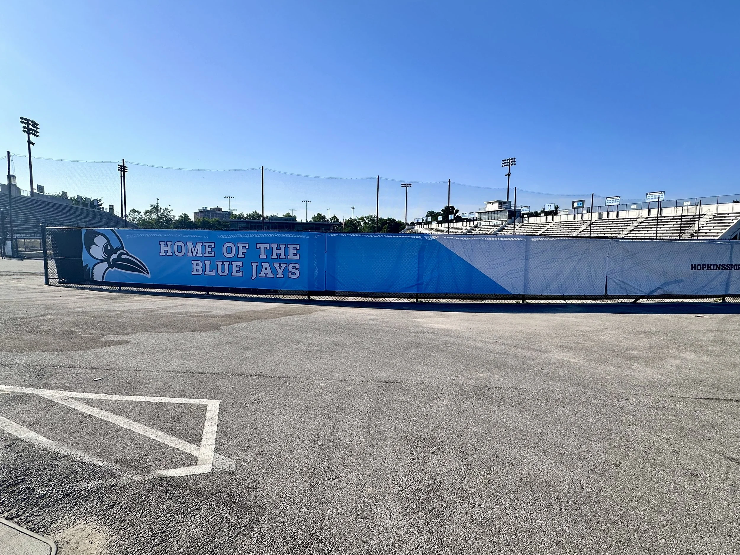 Empty football stadium with a blue banner that reads 'Home of the Blue Jays' and features a Blue Jay mascot logo.