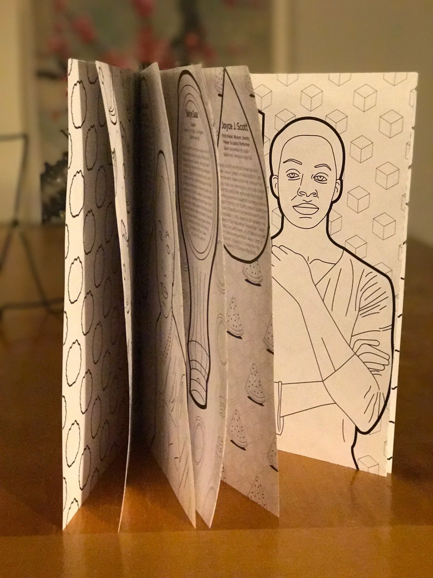 Open folded brochure with black and white illustrations, including a woman with short hair on the front panel, and images of a wooden spatula, a spoon, and sliced food inside.