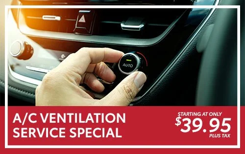 Close-up of a hand adjusting car air conditioning controls inside a vehicle with an advertisement overlay for A/C ventilation service special.