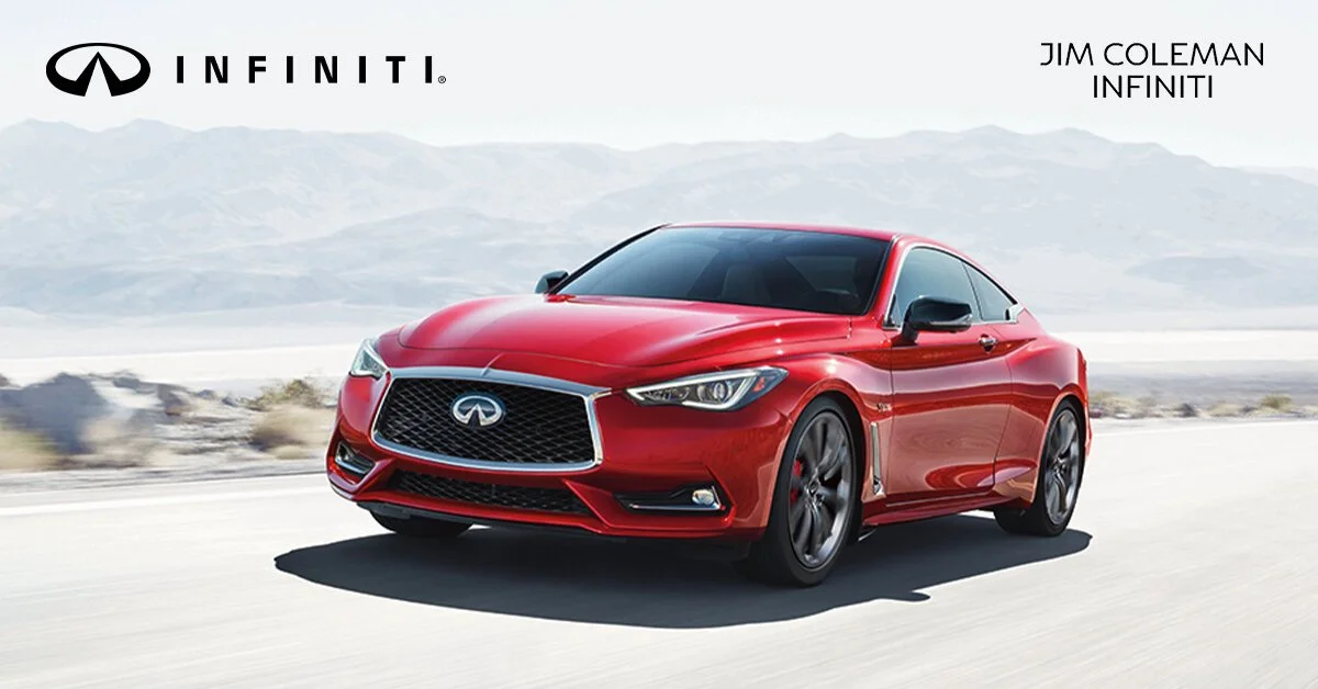 Red Infiniti sports car driving on a desert highway with mountains in the background.