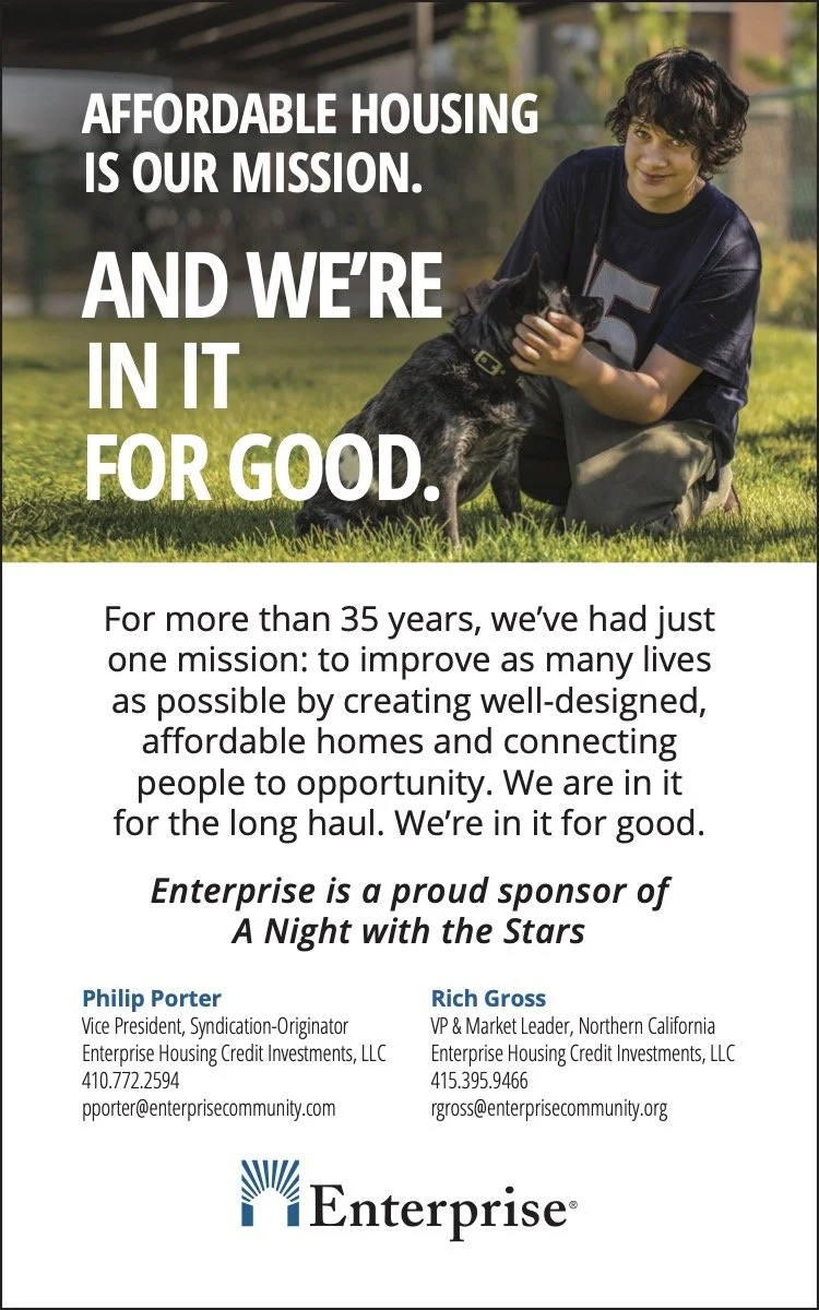 A young person kneeling on grass, petting a small black dog. The background shows a sunny outdoor area with a fence and trees. Text overlay reads: 'Affordable housing is our mission. And we're in it for good.'