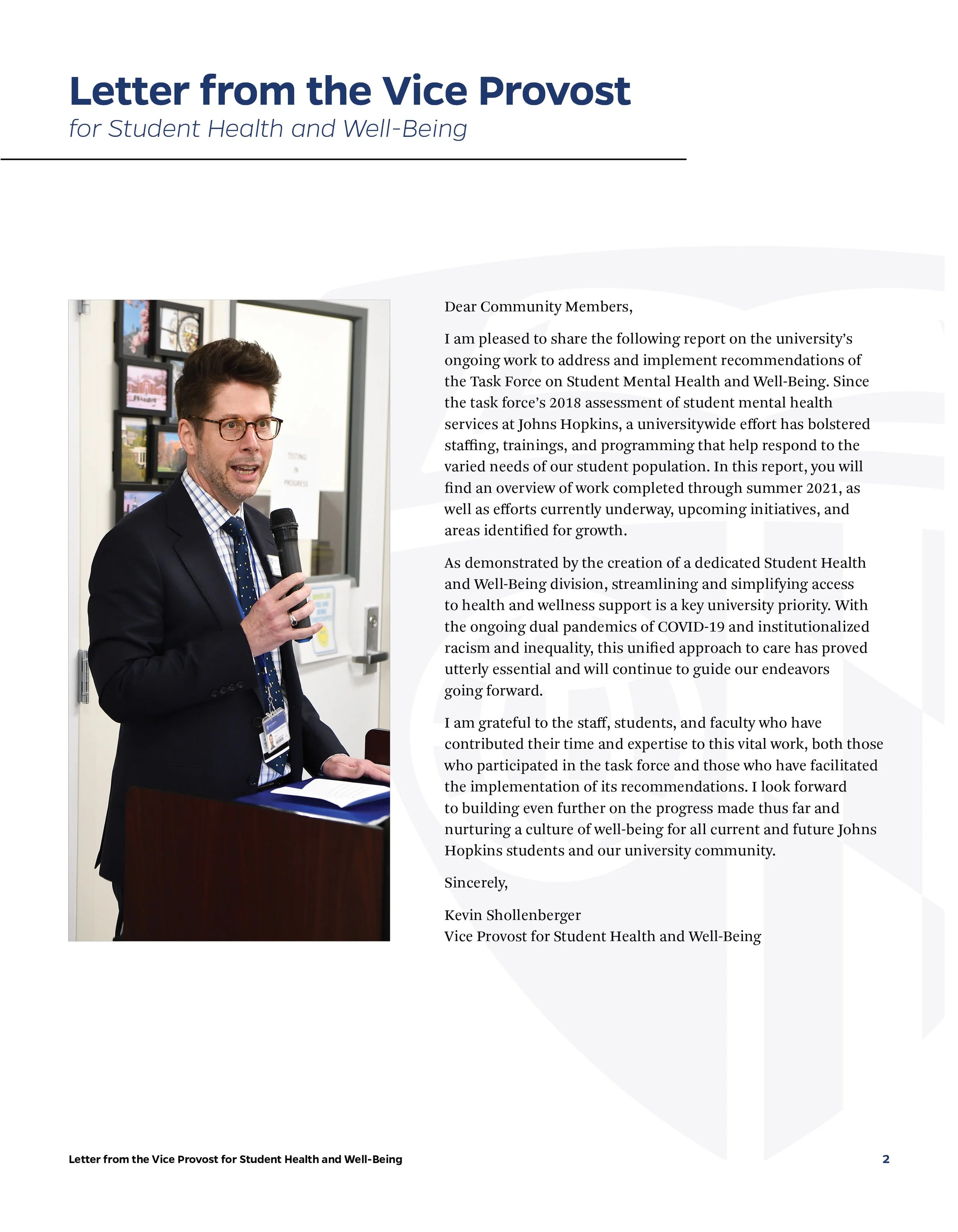 Letter from the Vice Provost for Student Health and Well-Being, featuring a photo of a man in a suit and glasses speaking into a microphone, standing at a podium, with a blurred background of photographs on a wall.