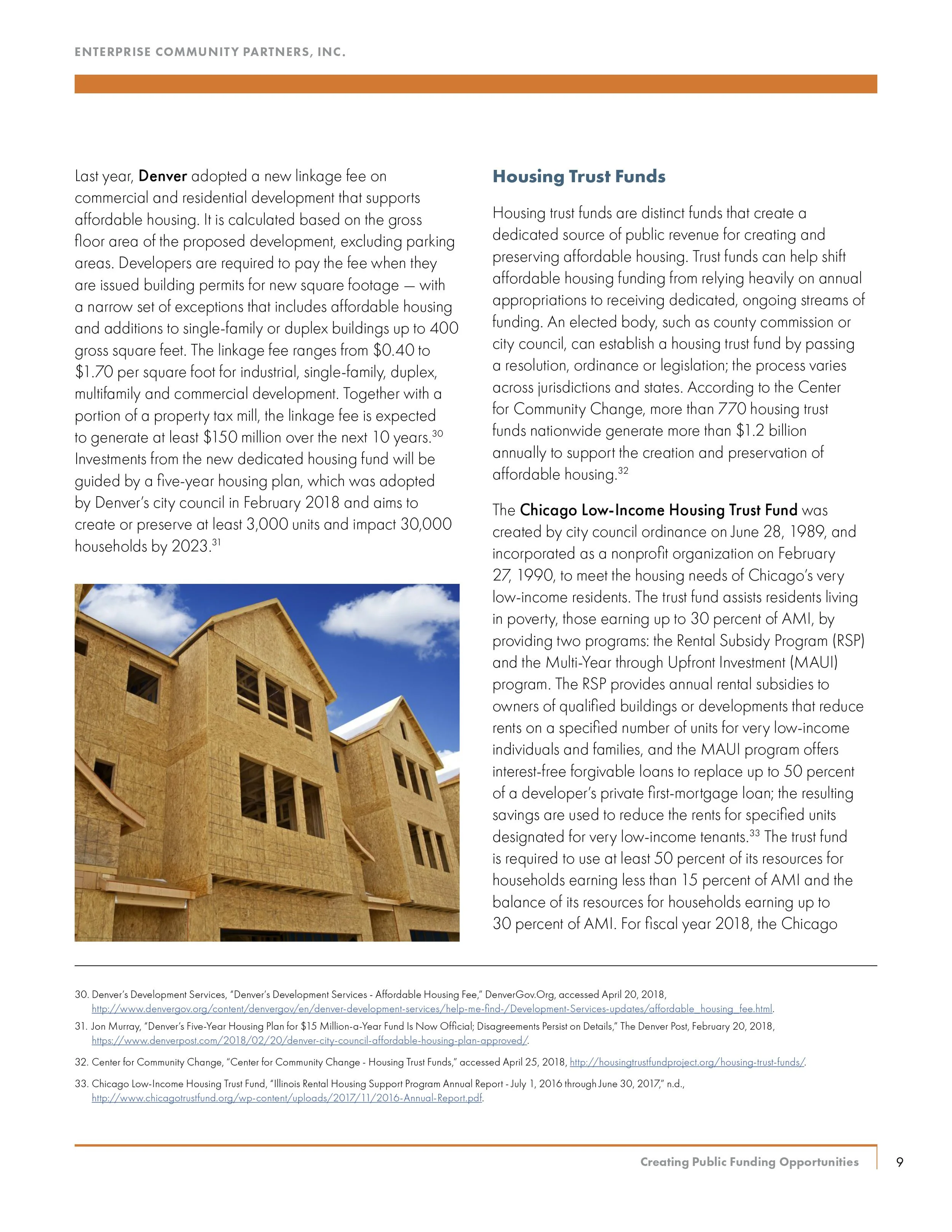 Photo of a multi-story residential building under construction with wooden framing and windows.