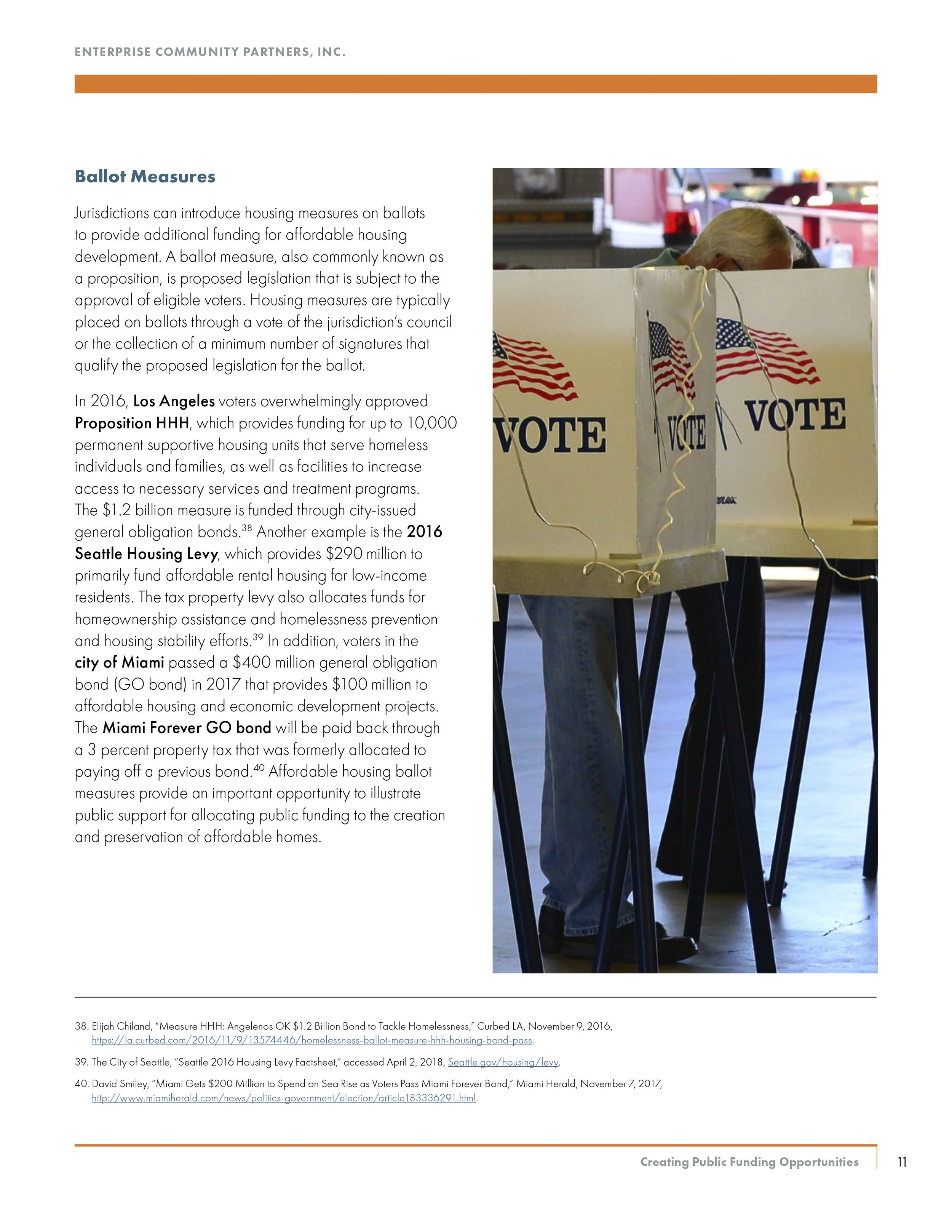 A person casting a ballot at a voting station with a cardboard booth decorated with American flags.