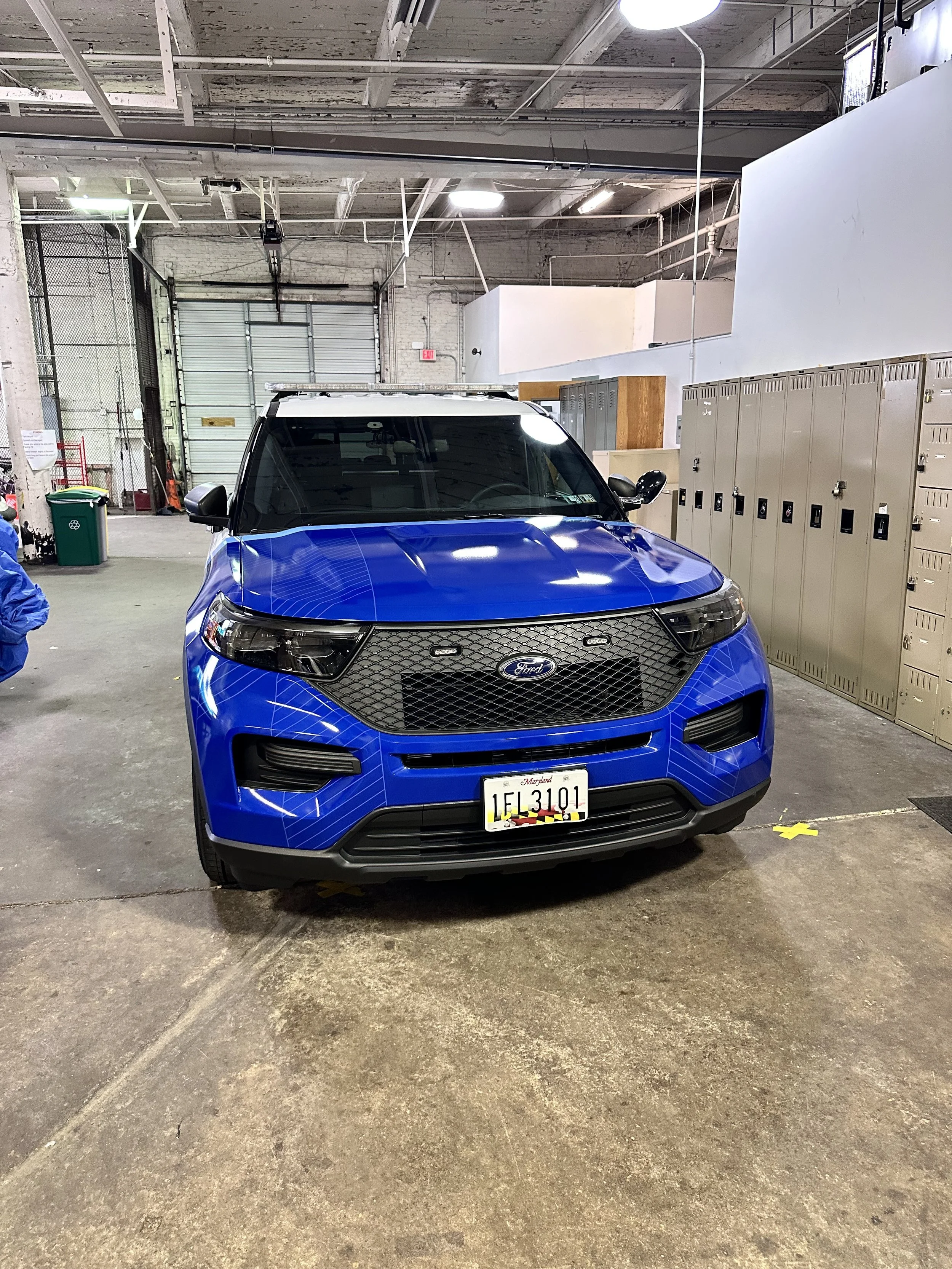 Blue Ford police SUV parked in an indoor garage.