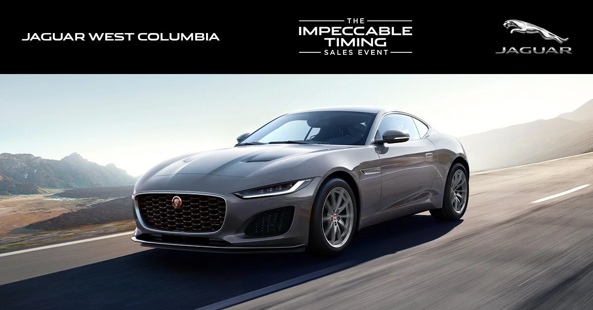 A silver Jaguar coupe driving on a road with mountains in the background during daytime, part of a Jaguar sales event advertisement.