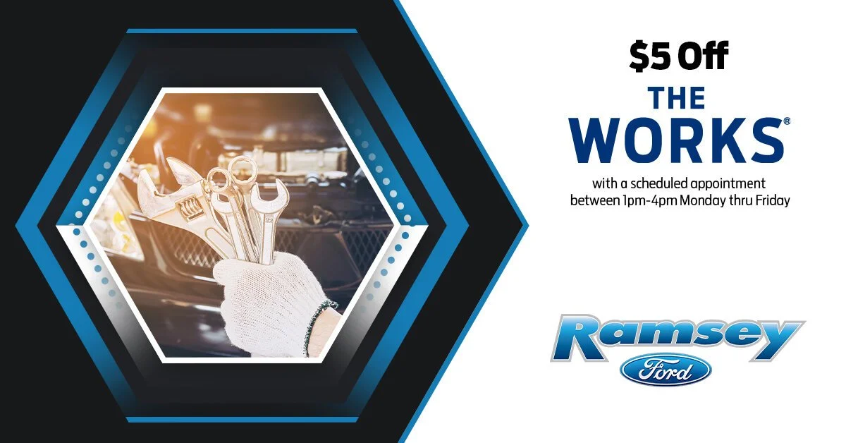 An advertisement for Ramsey Ford offering $5 off on services with an appointment between 1pm and 4pm, Monday through Friday. The image features a person's hand in a glove holding three wrenches inside a car.